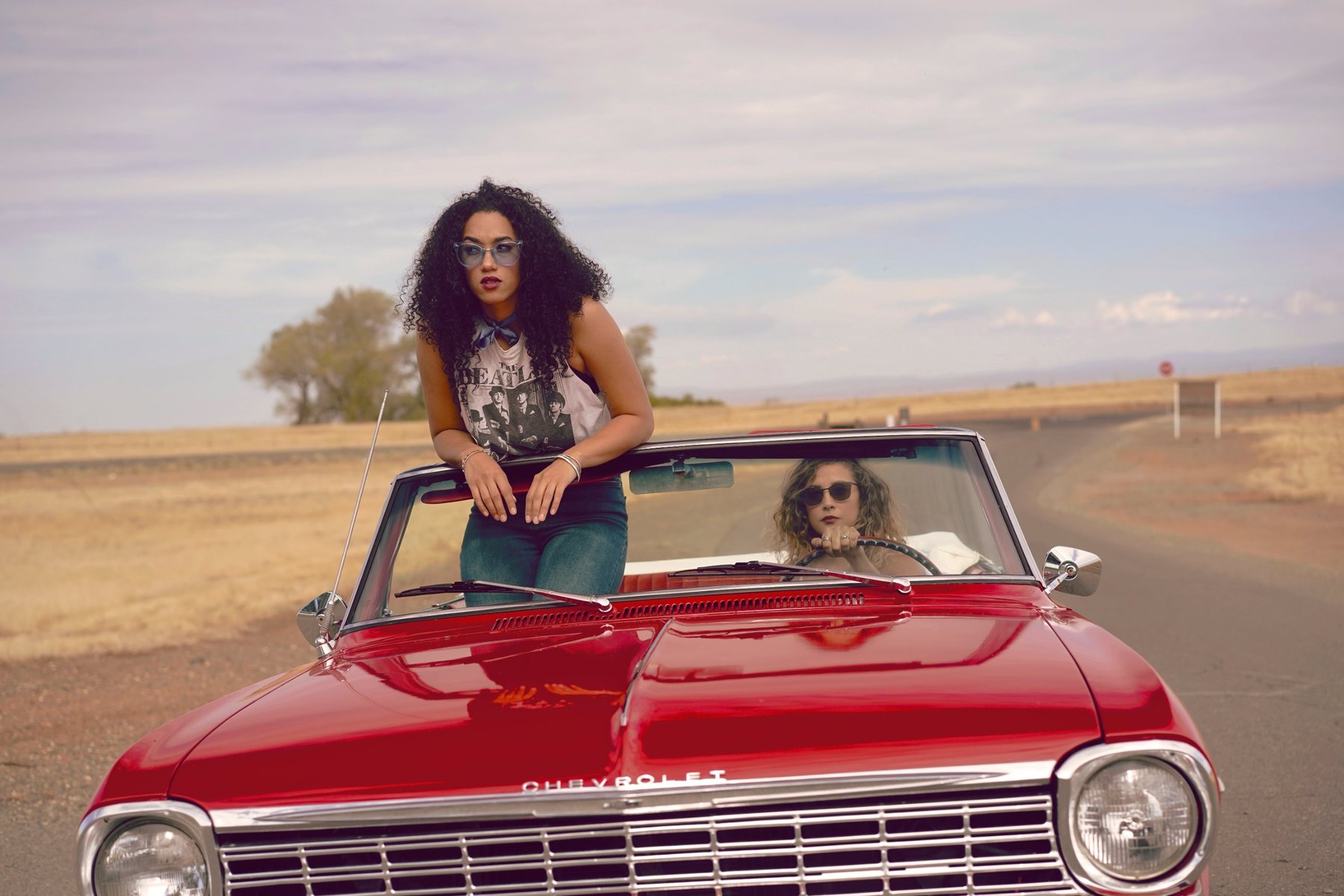 Woman standing in a red Chevrolet convertible